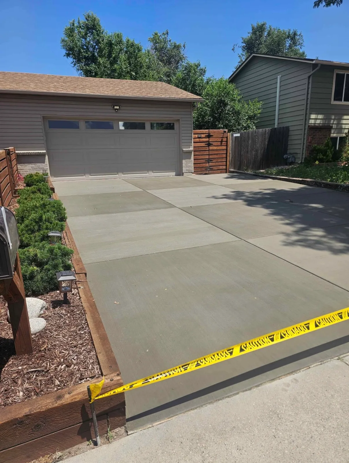 Wide concrete driveway apron finished in front of a garage