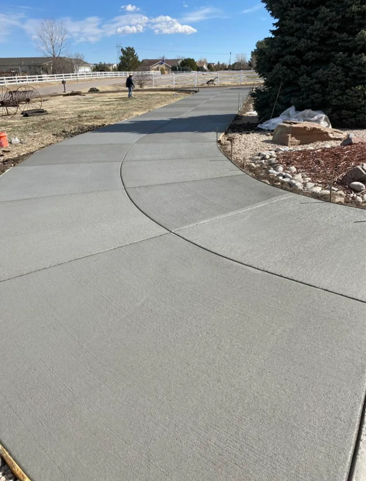 Curved concrete driveway edge set against a rock border