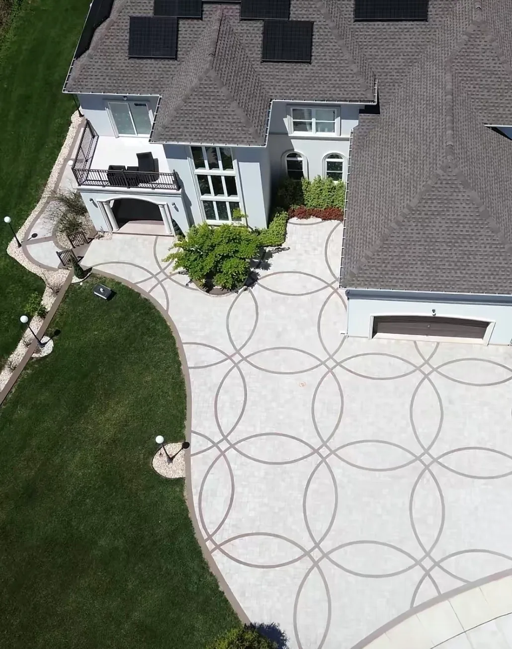 Decorative concrete driveway scored in an interlocking circle pattern beside a lawn