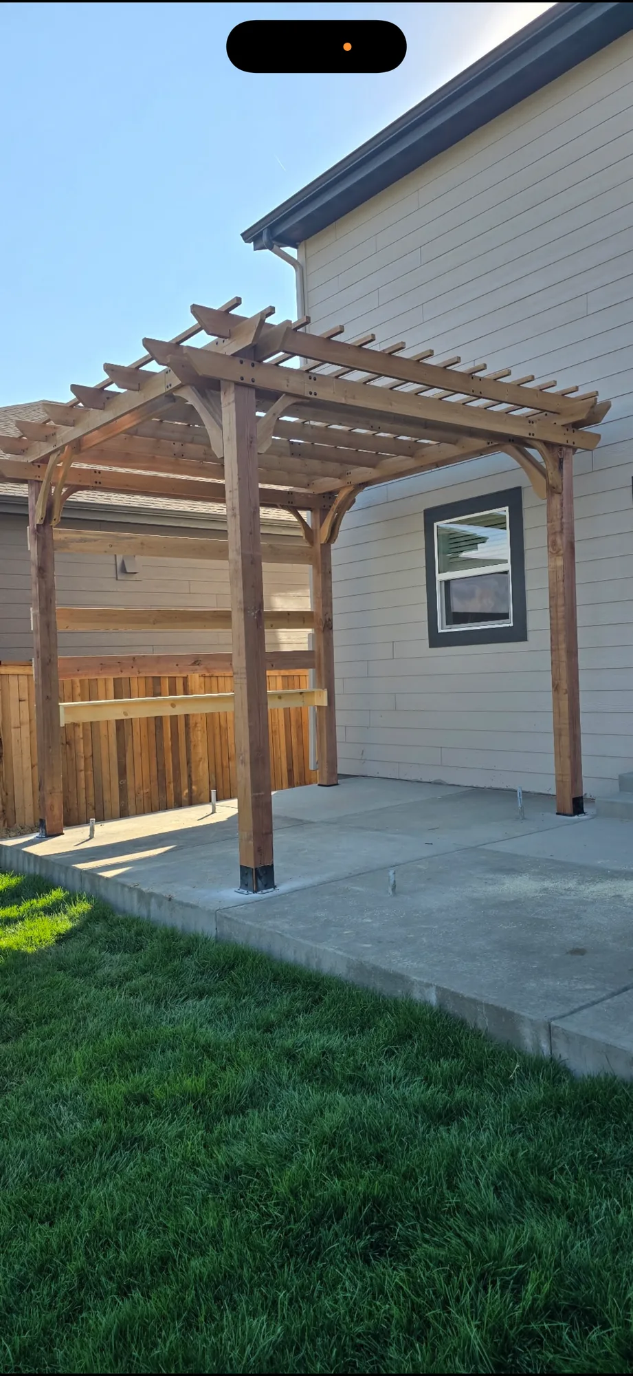 Cedar pergola built over a finished concrete patio