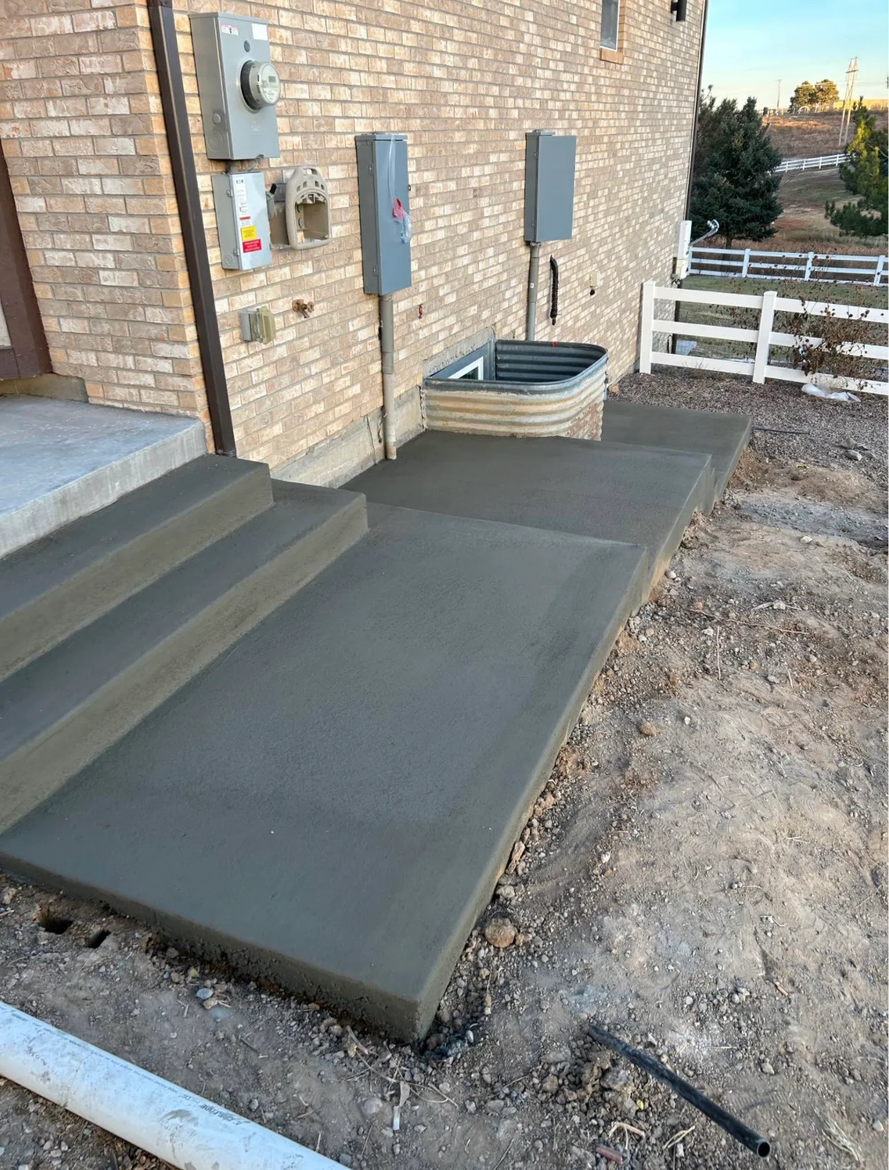 Poured concrete steps and landing at the side of a house