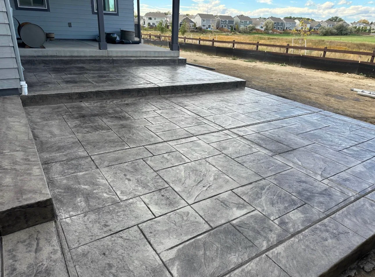 Stamped concrete patio wrapping around the back of a house