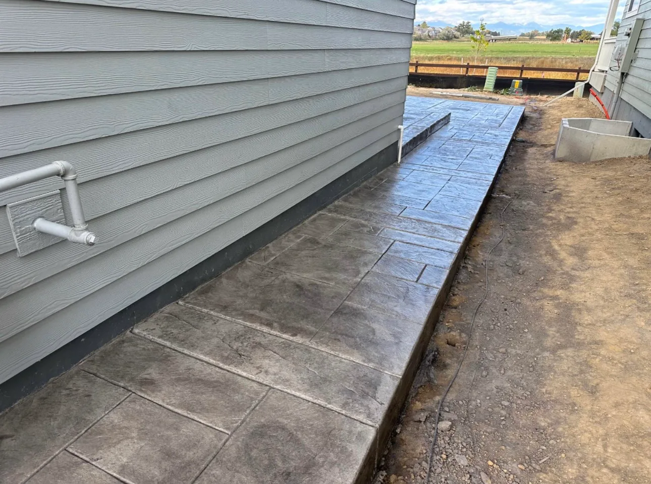 Stamped concrete walkway running the length of a house
