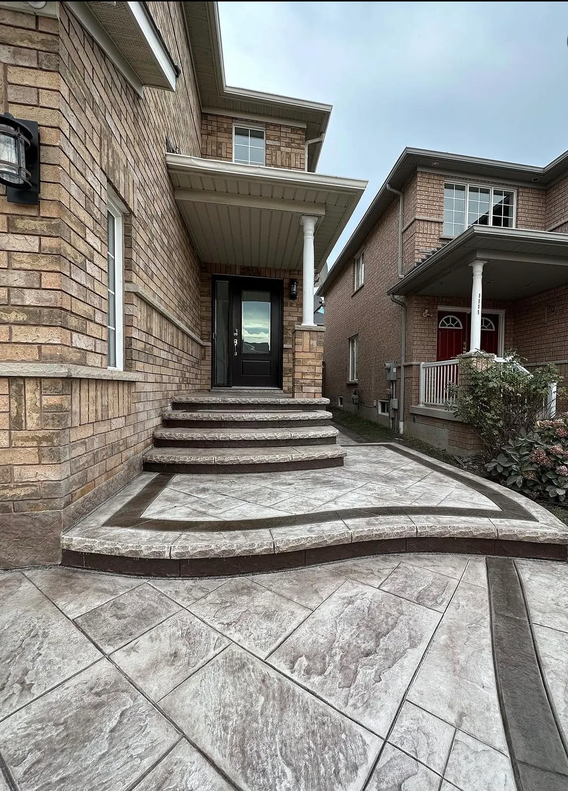 Stamped concrete steps and porch at the front of a brick house