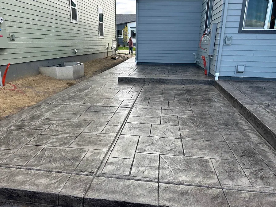 Stamped concrete patio extension wrapping around the back of a home