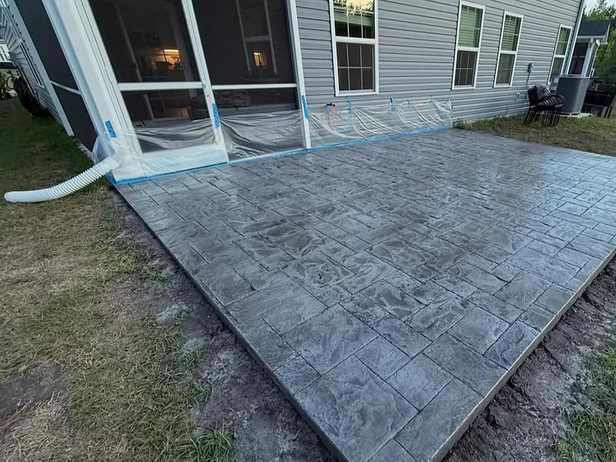 Stamped concrete patio laid against a stone and siding home