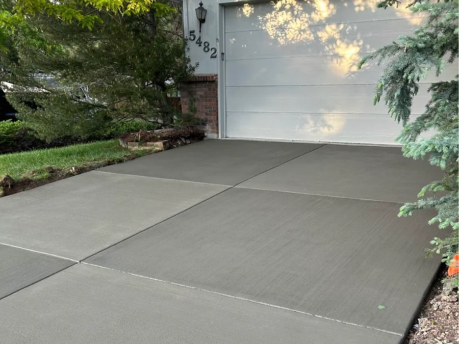 Freshly poured concrete driveway running up to a two car garage