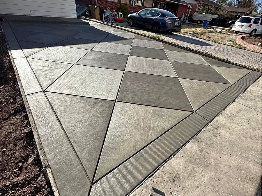 Driveway with a geometric decorative concrete inlay in two finishes