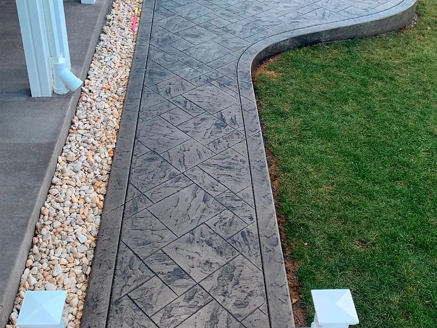 Stamped concrete walkway running between white porch railings